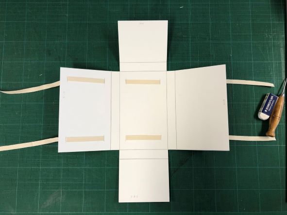 four flaps of a container and cotton tape to securely hold the volume. 